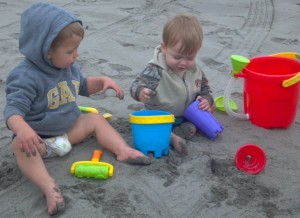 Baby boys playing with their toys in the Long Beach sand