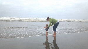 Playing with baby on the shore of the beach.